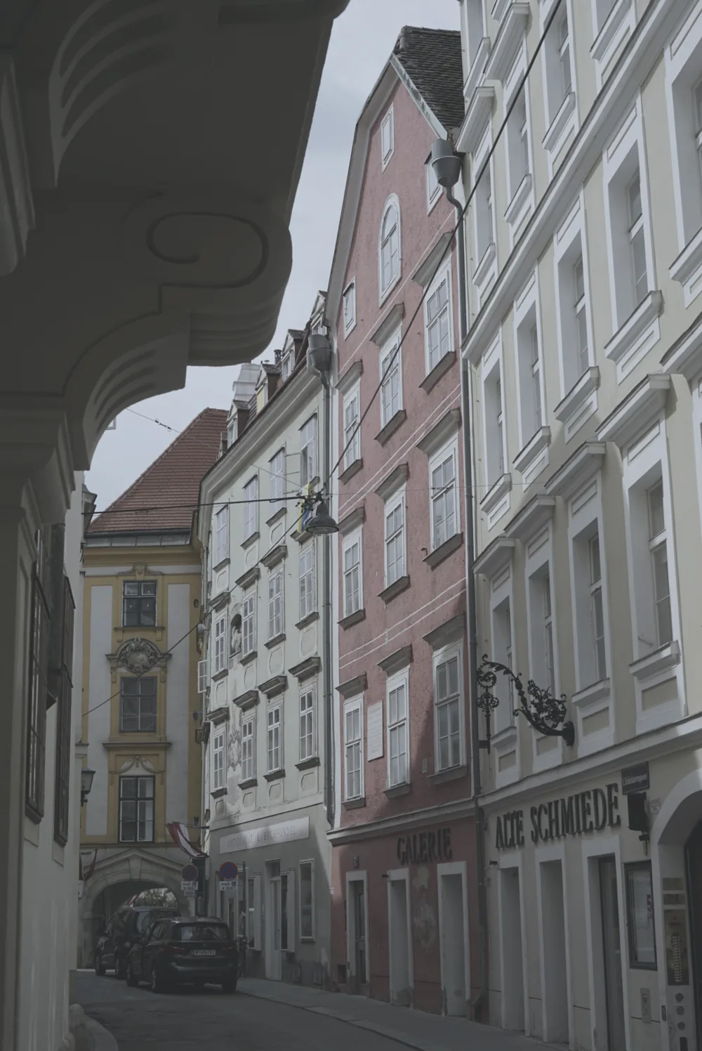 Unbearbeitetes Foto (vorher): dieselbe Gasse, flach und blass